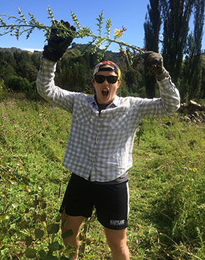 Rachelle conquers a pesky weed during a restoration project at Blue Duck Station in Whakahoro, New Zealand.