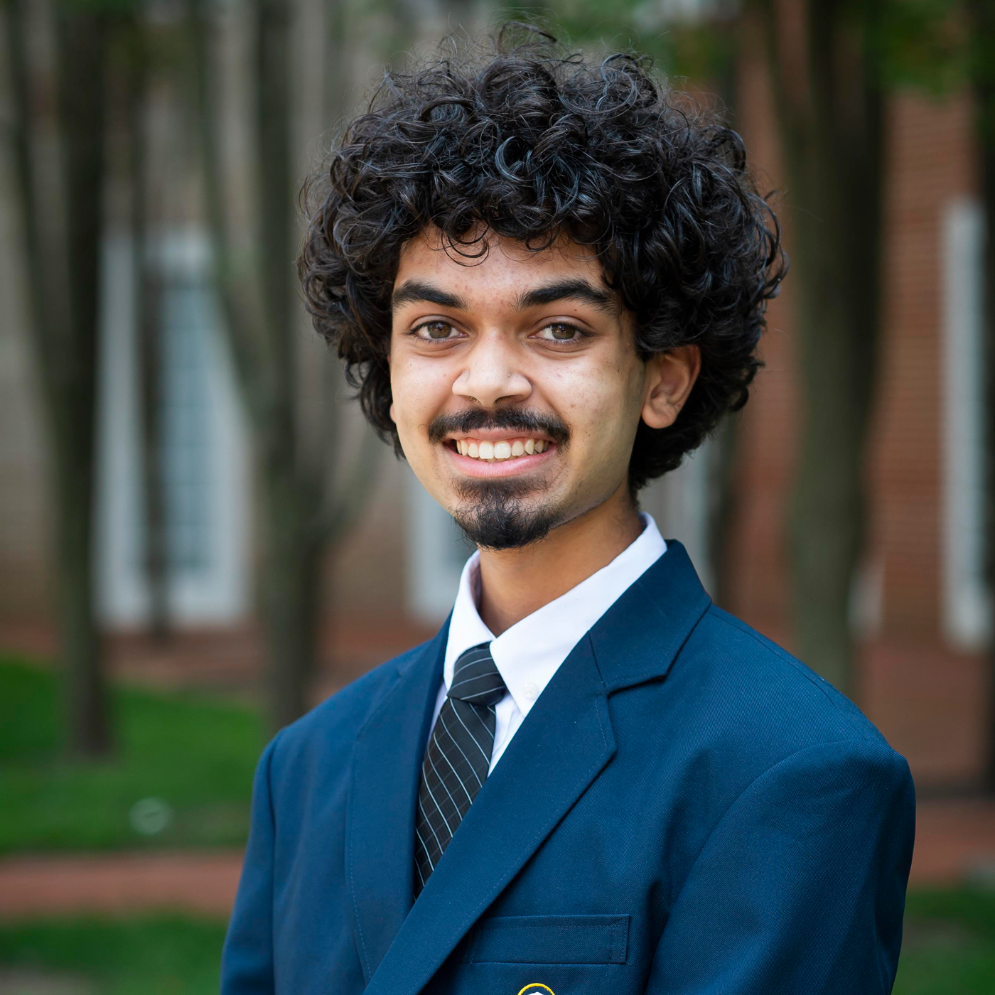 Young person smiling in a blue suit. 