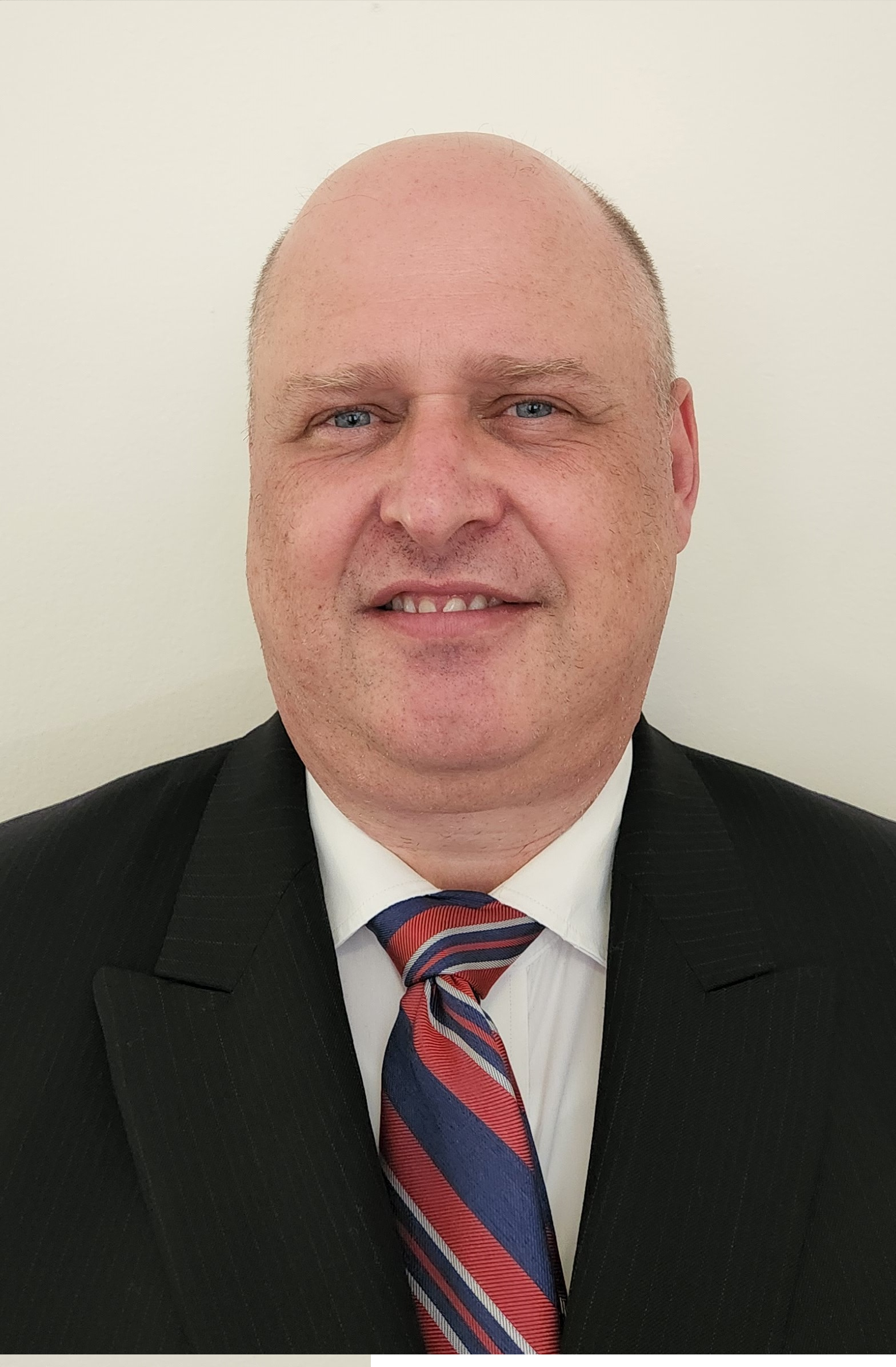 Man smiling and wearing a suit and tie