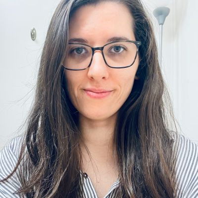 Young woman with a soft smile wearing glasses