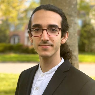 Young person wearing a suit and glasses