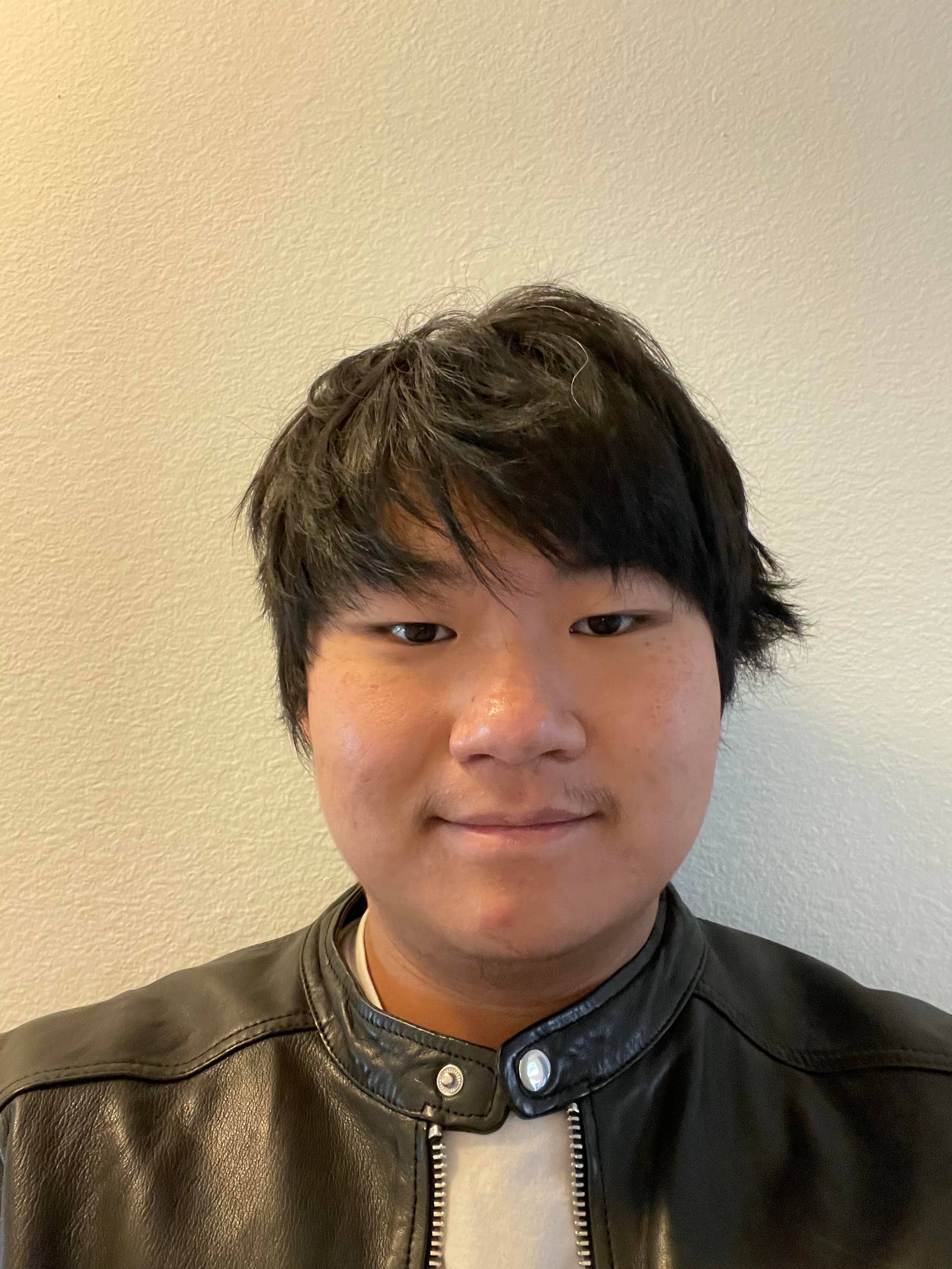 Young man with a soft smile wearing a leather jacket