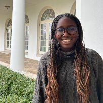 Young woman smiling in front of columns at the White House.