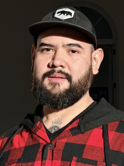 man wearing a baseball hat and a flannel jacket