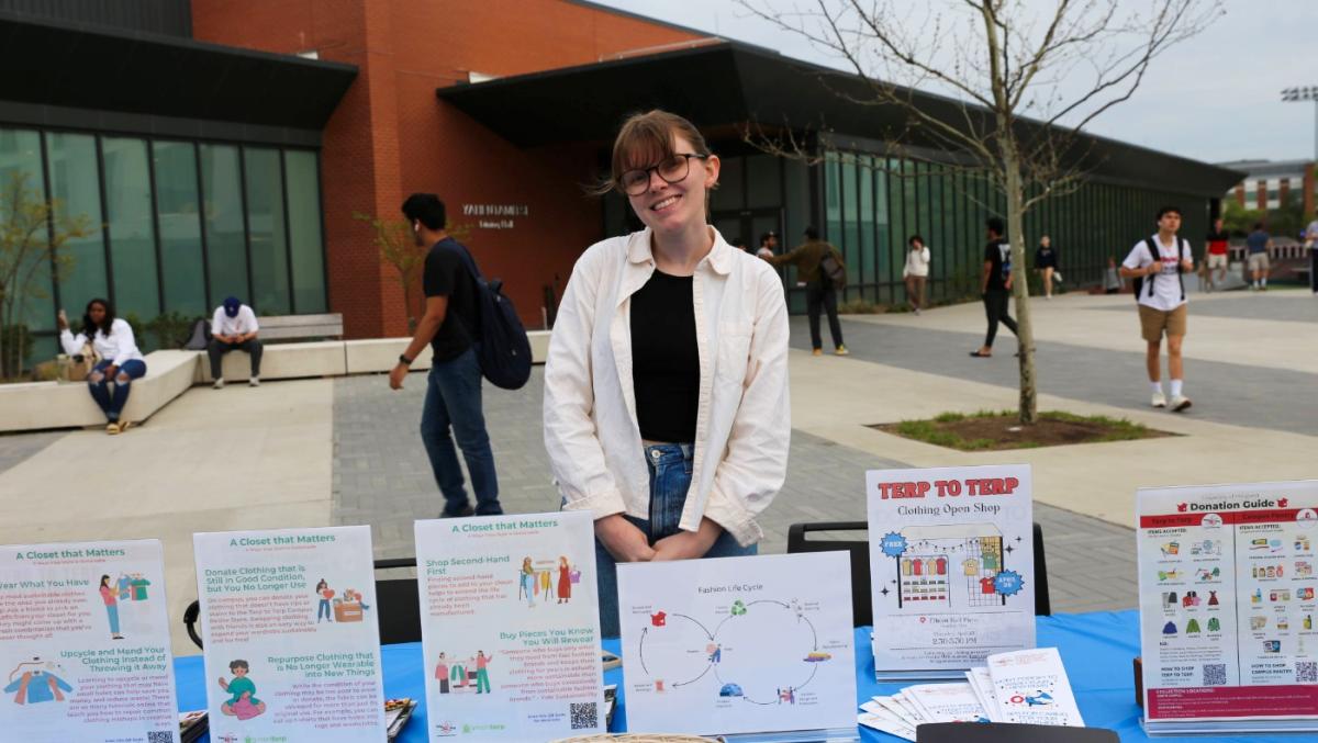 A Terp to Terp program assistant presenting educational materials at a tabling event outside Yahentamitsi Dining Hall.