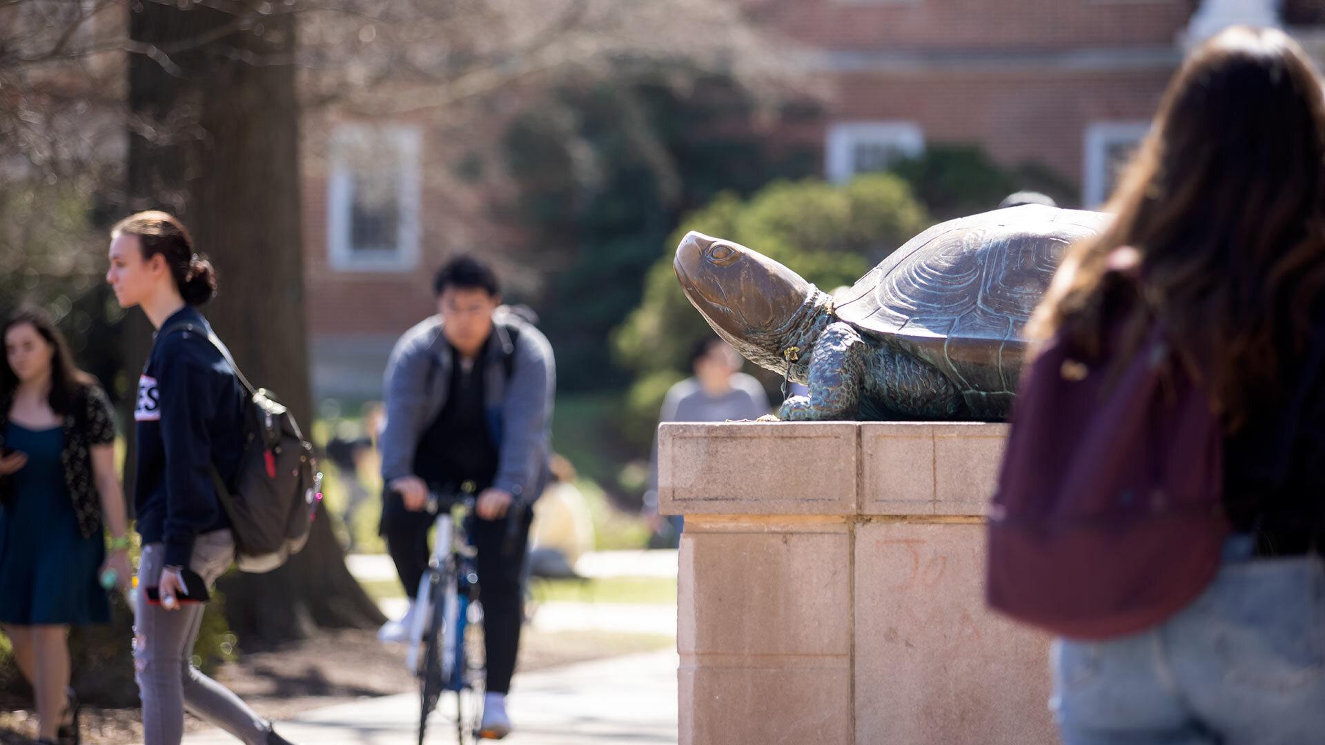 Students walk by the Testudo terrapin statue on UMD campus