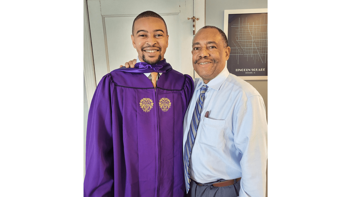 Chris Riggs in a graduation gown standing next to Leonard Riggs.