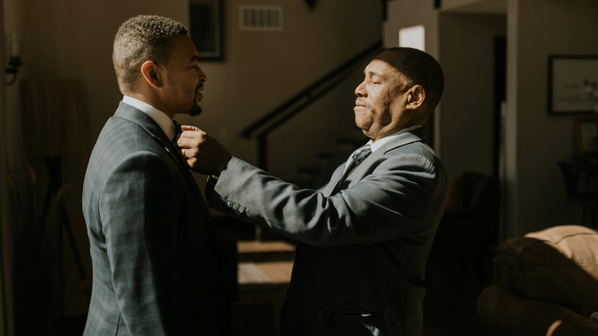 Leonard Riggs placing corsage on Chris Riggs. 