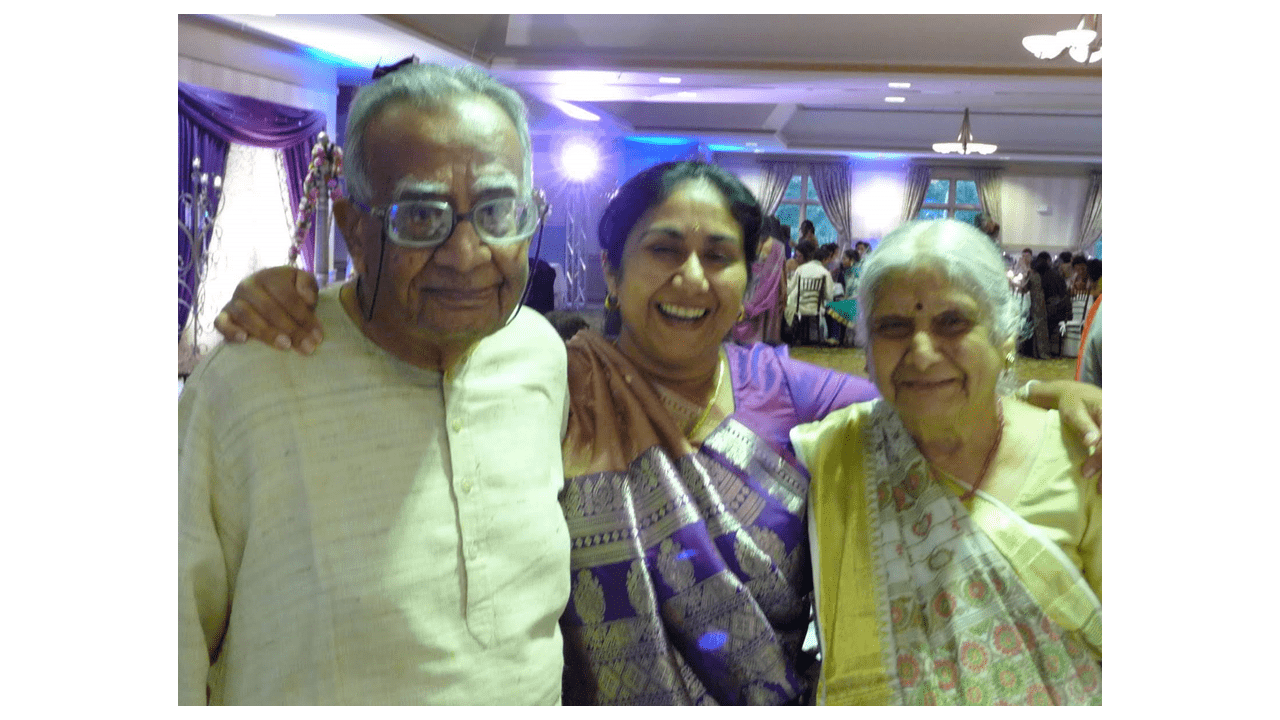 Jahanvi Desai standing between two other individuals and smiling. 