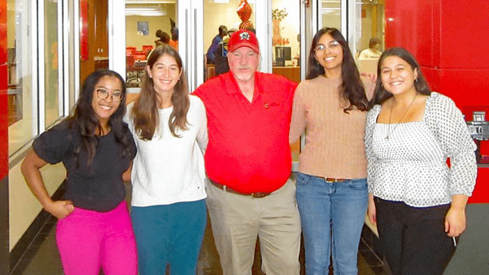 Rocky Lopes standing with students.