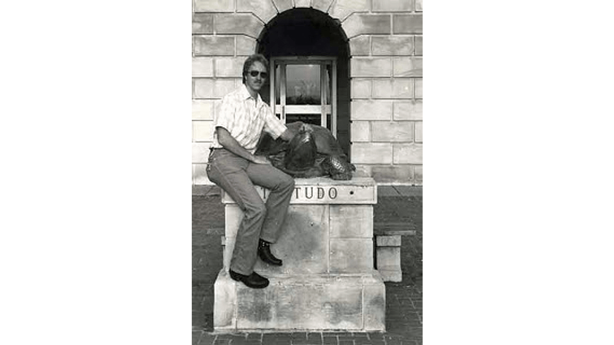 Rocky sitting next to Testudo statue. 