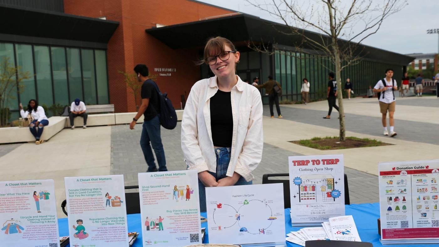 A Terp to Terp program assistant presenting educational materials at a tabling event outside Yahentamitsi Dining Hall.