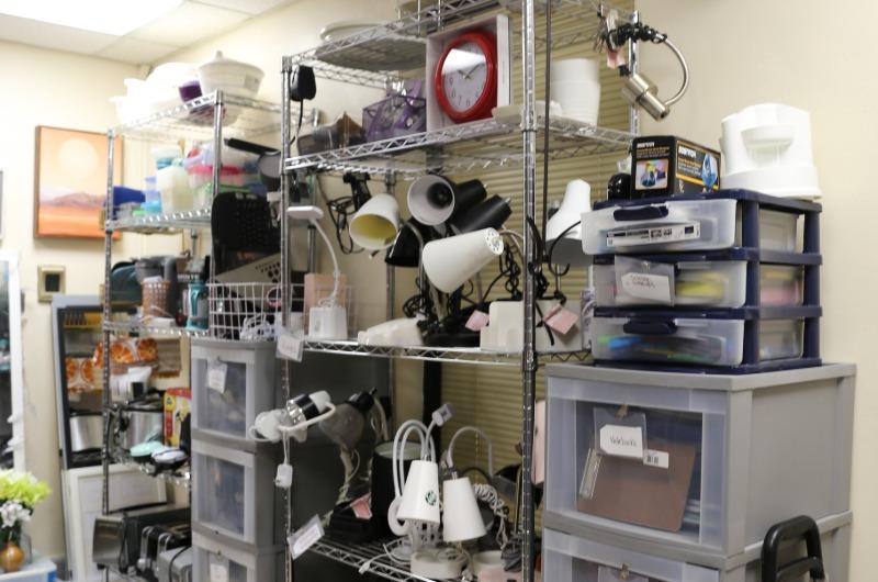 Shelves of donated lamps, kitchenware and school supplies at the Campus ReUse Store.